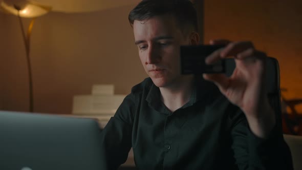 Young Handsome Man Making Online Purchase with Credit Card and Laptop