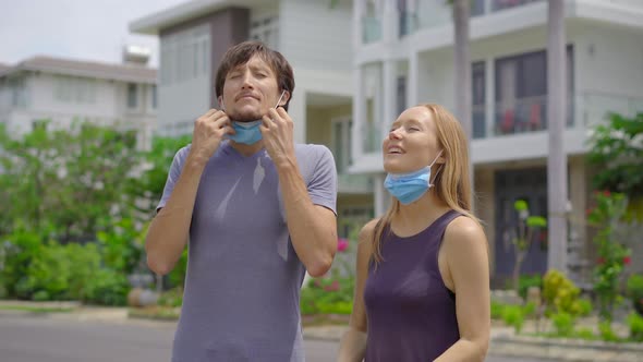 Quarantine Is Over Concept. Woman and Man Take Off Medical Masks on a Street. We Are Safe