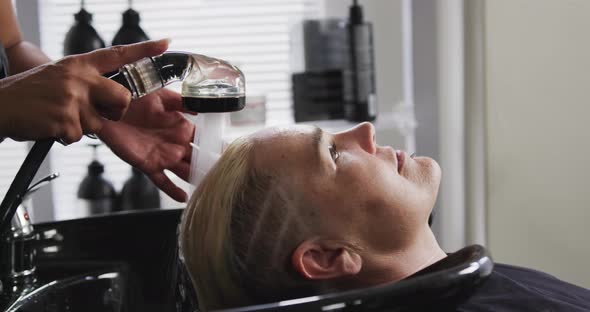 Side view woman having her hair washed by a hairdresser