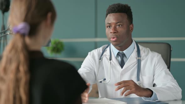 African Doctor Talking to Patient in Office