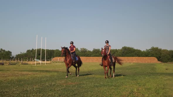 Two Females Equestrians Riding Horses at Country Racetrack