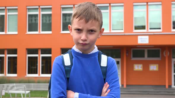 A Young Boy Is Angry - an Elementary School in the Background