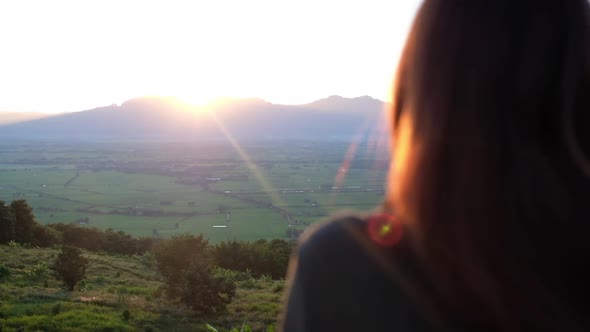 Slow motion of a young woman watching sunset and mountain views in the evening