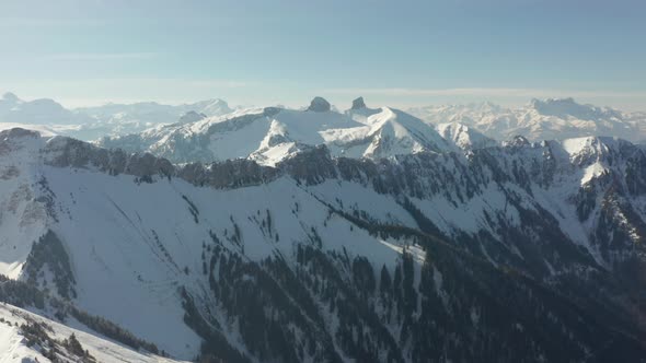 High angle view of beautiful snow covered valley filled with green pine trees