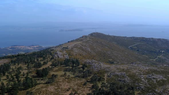 Aerial Approaching Over Hillside With Path Leading To Radio Mast Overlooking Ría de Arousa In Backgr