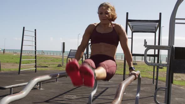 Sporty Caucasian woman exercising in an outdoor gym during daytime