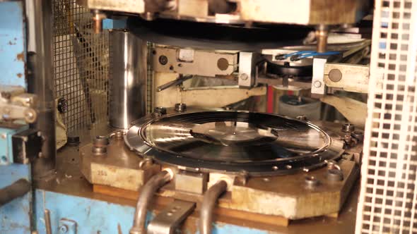 Vinyl record pressing machine in action, Making music record in a vinyl factory