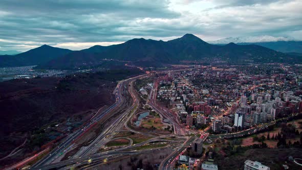 Aerial view dolly in of the commune of Vitacura the Manquehue hill in the background with clouds, Sa