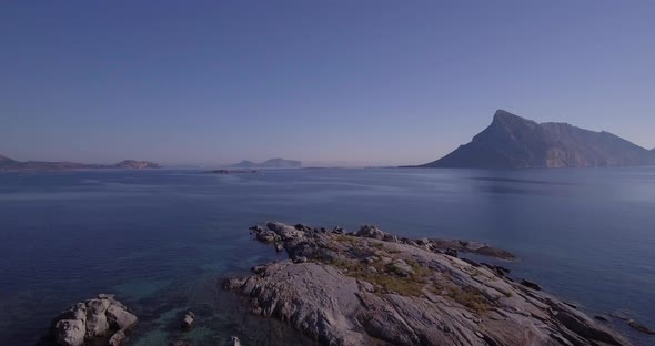 Aerial, A View On A Tiny Stone Island In Sardinia, With Tavolara Island On A Background