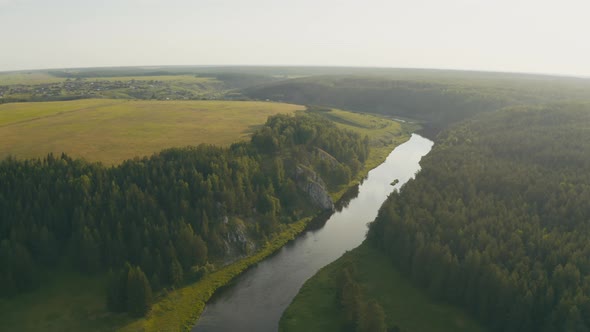 Aerial View of the River with a Rock and Forest on the Banks