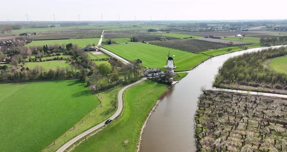 Aerial view of river Linge with road, mill and orchards, Betuwe, Netherlands