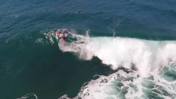 Aerial view of a man sup stand-up paddleboard surfing in Hawaii