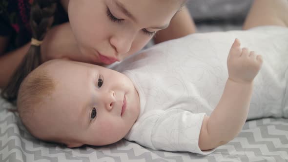 Sister Kiss Adorable Baby Brother. Close Up of Girl Lovely Kiss Baby Boy Face