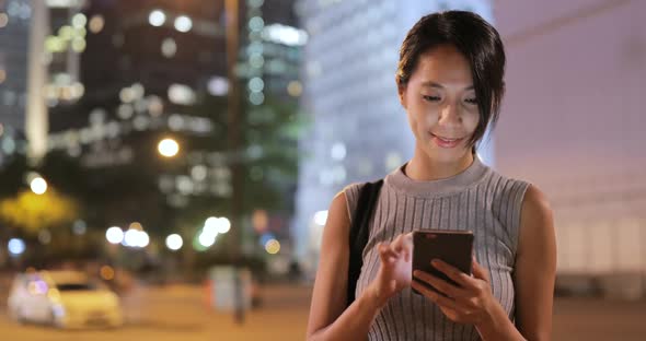 Woman using mobile phone at night