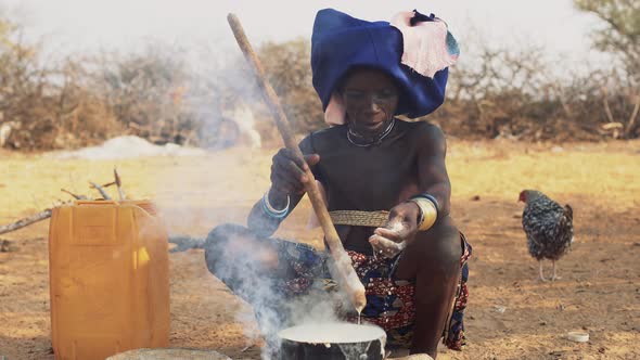 Old Mucubal woman cooking in the traditional way, Angola