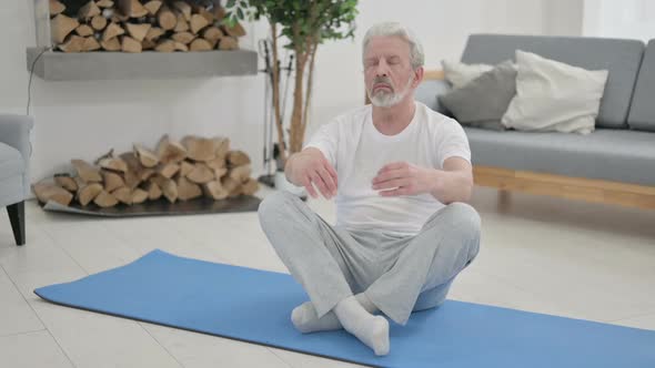 Old Man Meditating on Yoga Mat at Home