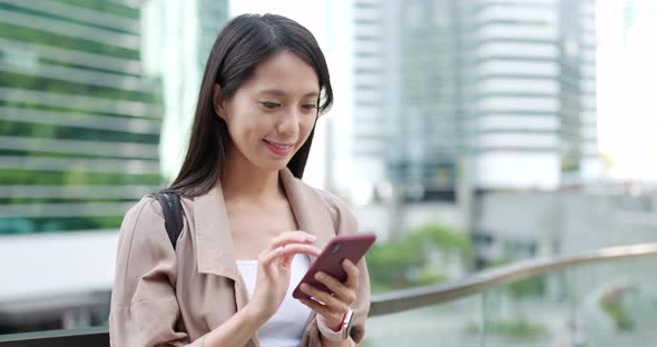 Asian woman sending sms on mobile phone