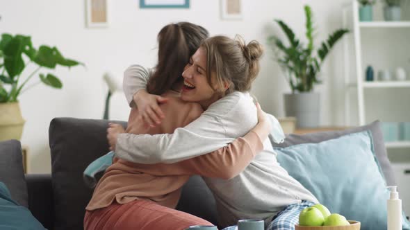 Happy Women Taking Medical Masks off, Smiling and Embracing at Home