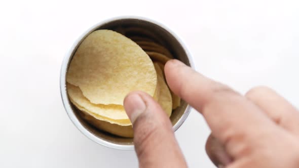 Hand Pick a Potato Chips Form a Container on White Background