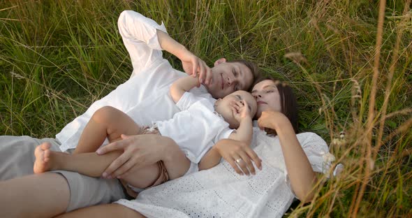 Young Family with Son Relaxing on a Meadow