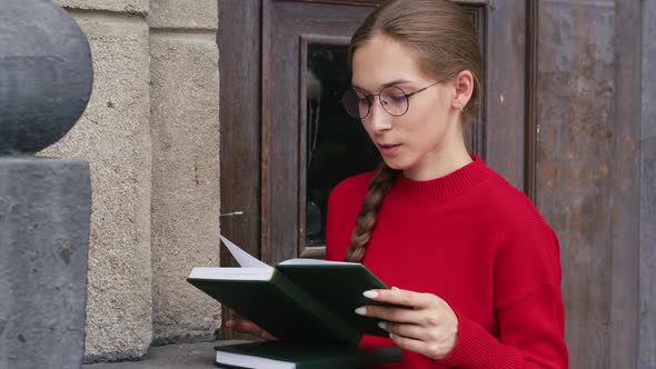 Young Woman Looks Through Daily Todo List in Diary