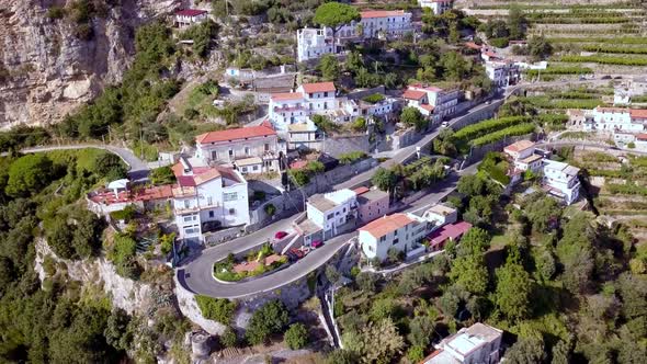 Italian Amalfi coastline road turn with terraces near Positano, Aerial drone top view lowering shot