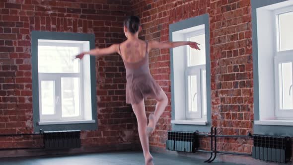 A Smiling Ballerina Girl Training Her Dancing in the Studio