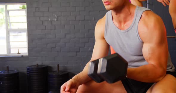 Muscular man exercising with dumbbell