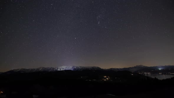 Nighttimelapse in the Mountains with View on the Lake and the Stars in Winter