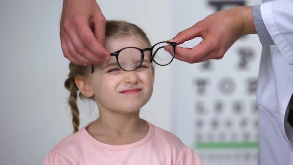 Optician Putting Glasses on Little Girl and Making Her Happy, Professional Help