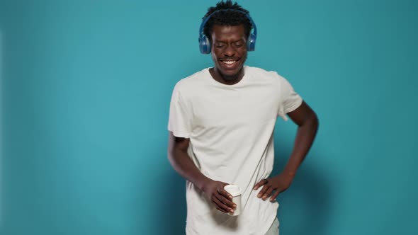 Portrait of Man with Headphones Jumping and Dancing to Song