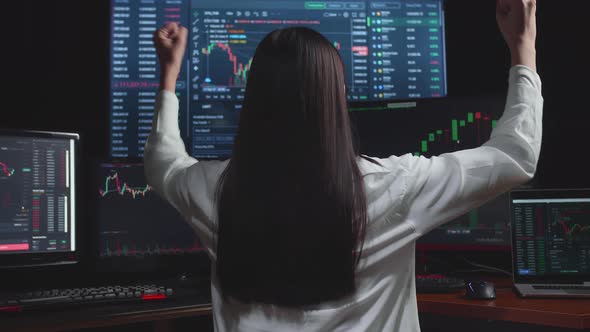 Asian Female Stock Market Broker Working On Computer And Celebrating With Analysing Graphs