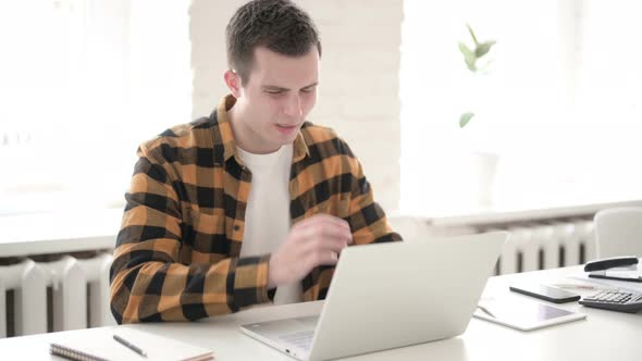 Casual Young Man with Headache Working on Laptop