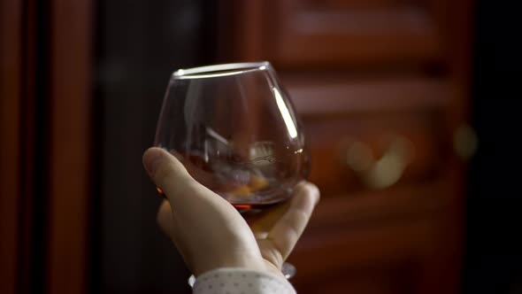 A Glass of Cognac in a Man's Hand