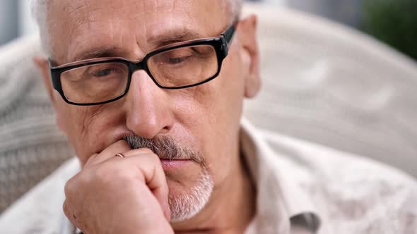 Closeup Elderly Grandfather in Glasses Worried Touching Chin