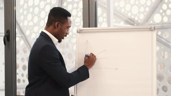 African American Architec Engineer Drawing Plan on Flip Chart at Office