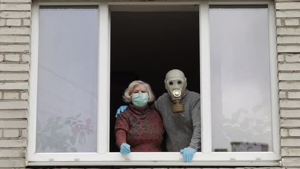 Old Grandparents Stay at Window Isolated at Home on Quarantine. Coronavirus