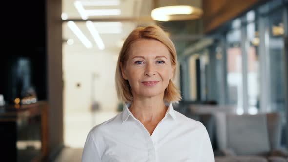 Portrait of Attractive Mature Businesswoman Smiling Looking at Camera in Cafe