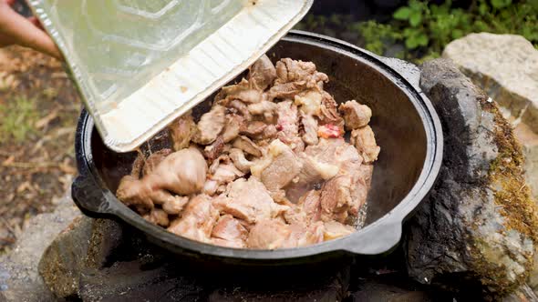 Steak and Liver Frying in a Cauldron While Camping in the Mountains