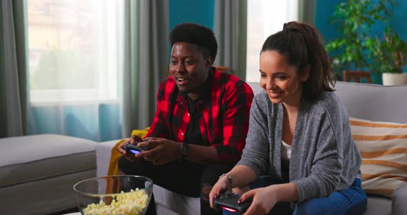 Cheerful Mixedraces Couple African American Man and Caucasian Woman Resting in Room Sitting on Sofa