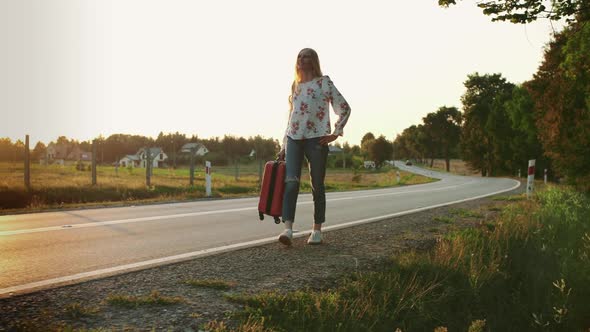 Cheerful Woman with Suitcase Walking on Road.