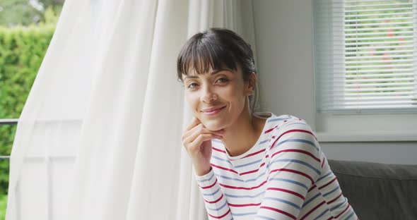 Portrait of happy caucasian woman wearing blouse in living room