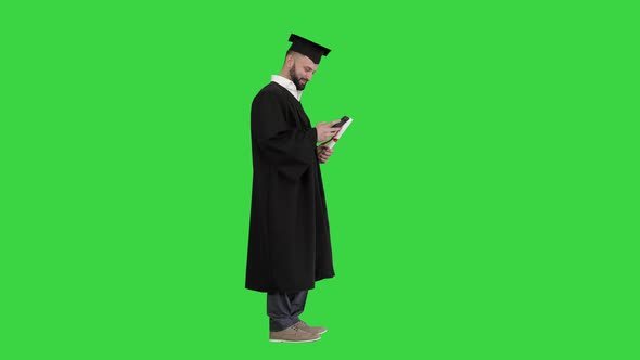 Graduate Student Texting on the Phone on a Green Screen, Chroma Key.