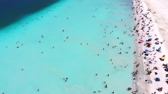 People Swim on Vacation in the White Sandy Beach of the Clear Tropical Turquoise Light Blue Sea