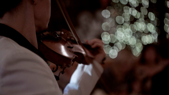 Man Playing Violin and Dancing People