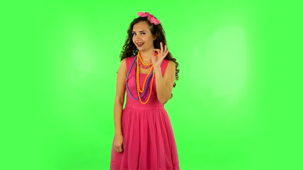 Lovely Girl Smiles Broadly, Winks and Makes Sign Ok. Green Screen