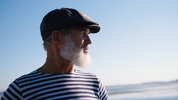 Portrait of an Old Man with a White Beard Looking Into the Distance on the Seashore or Ocean