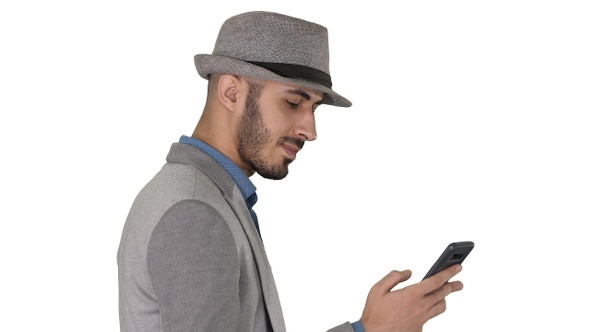 Casual man texting on phone and walking on white background.