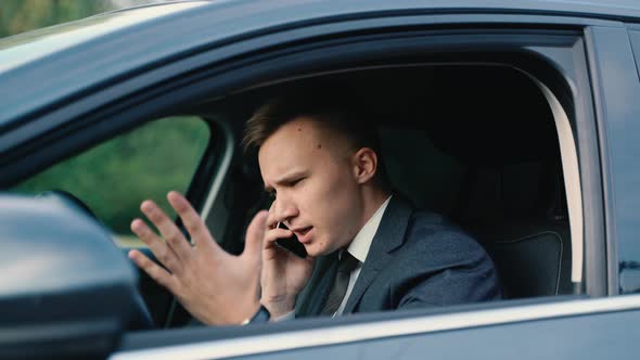 Stressed Businessman Calling on a Mobile Phone in the Car