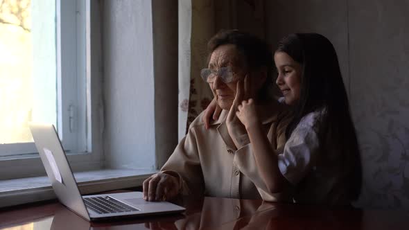 Great Grandmother and Granddaughter Wave To Family on Computer